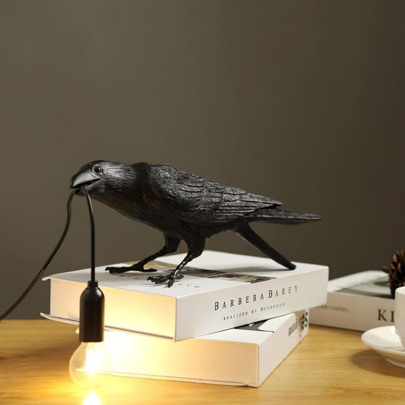 Stolní lampa s havranem držícím žárovku