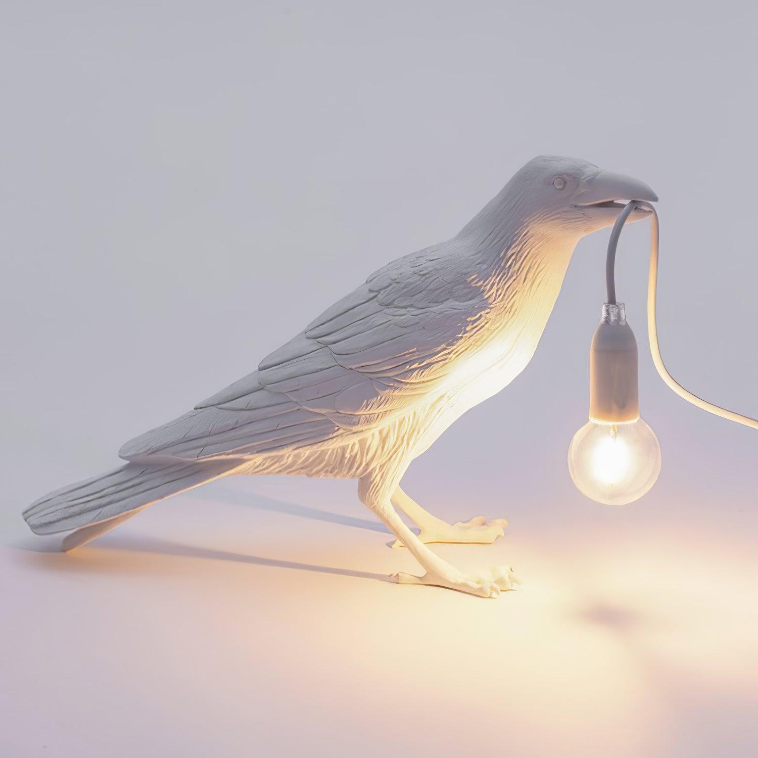 Stolní lampa s havranem držícím žárovku