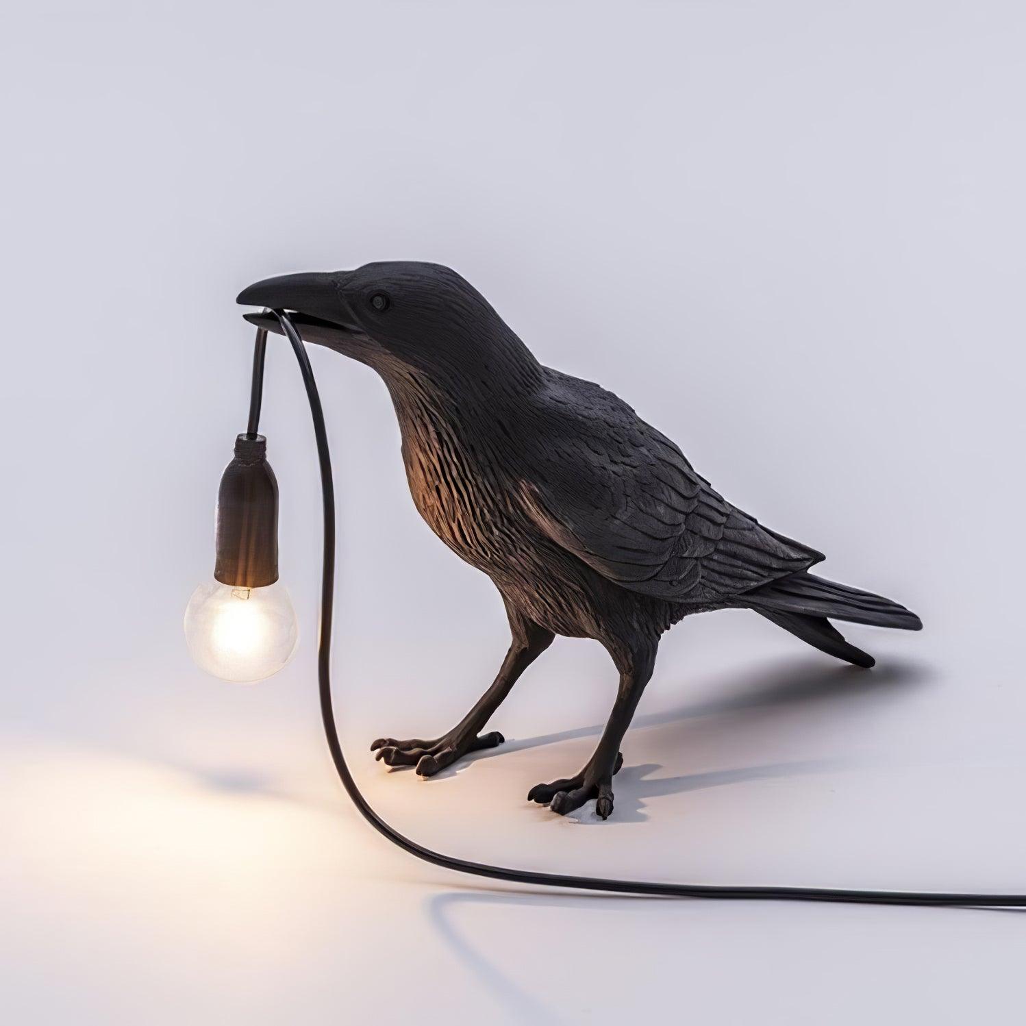 Stolní lampa s havranem držícím žárovku