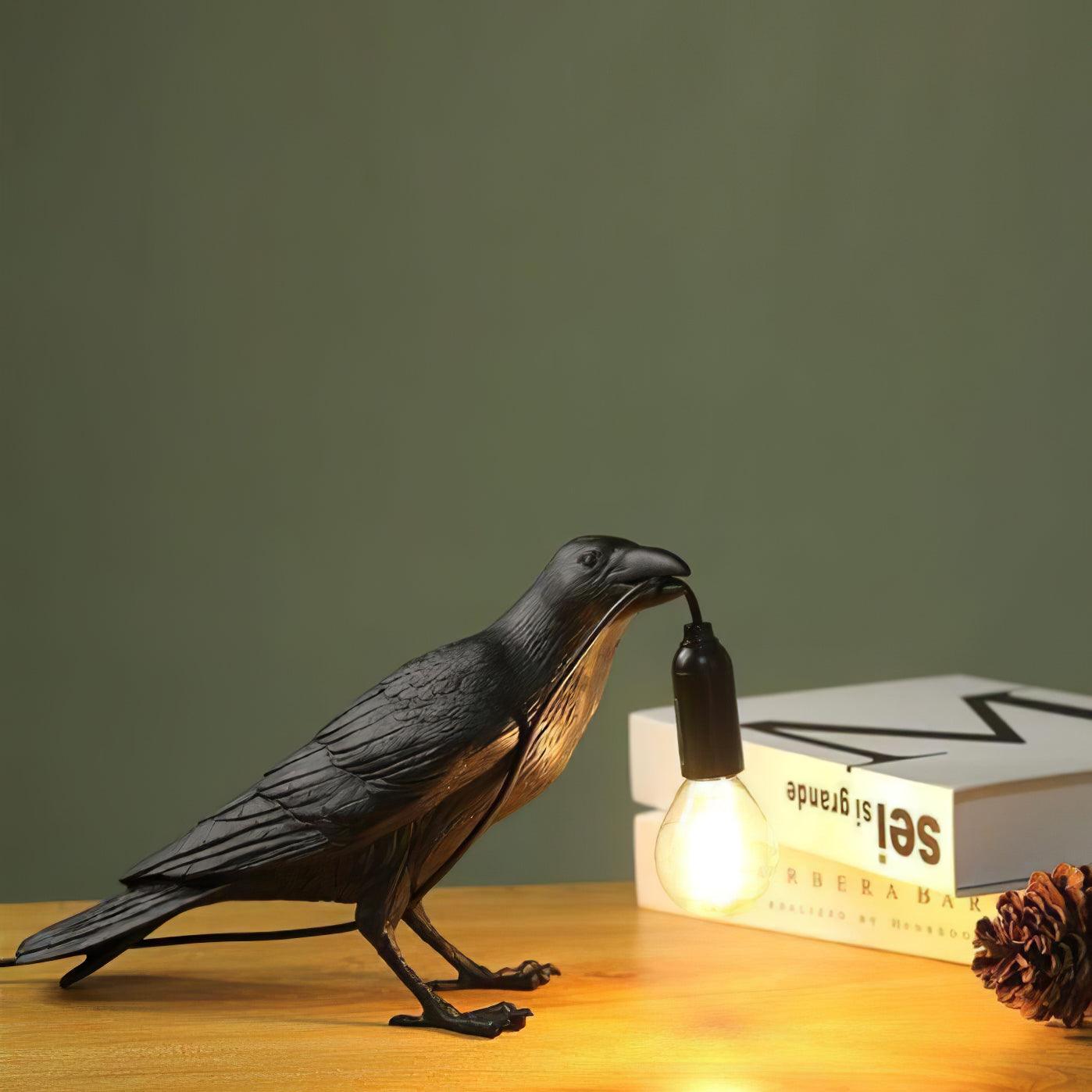 Stolní lampa s havranem držícím žárovku