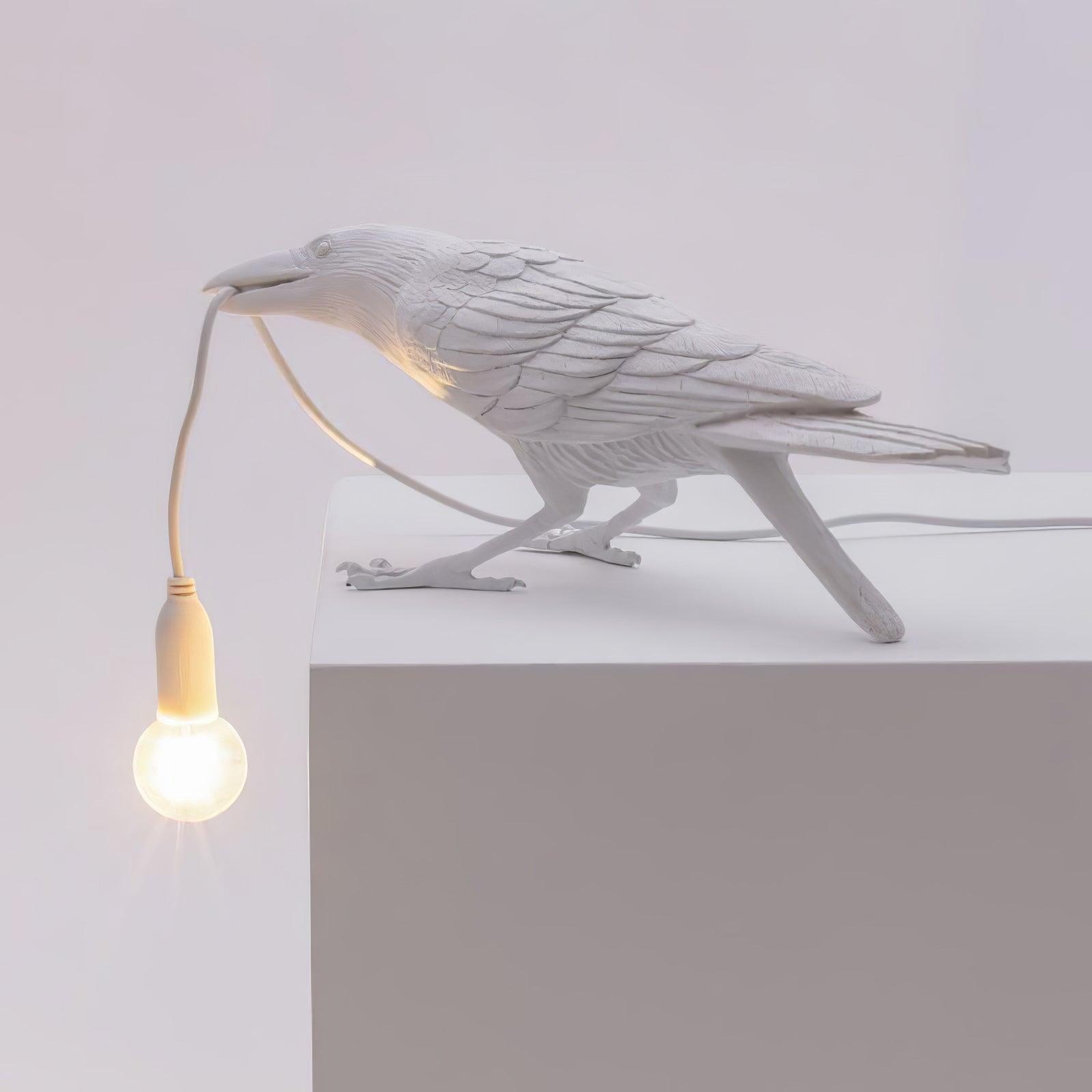 Stolní lampa s havranem držícím žárovku