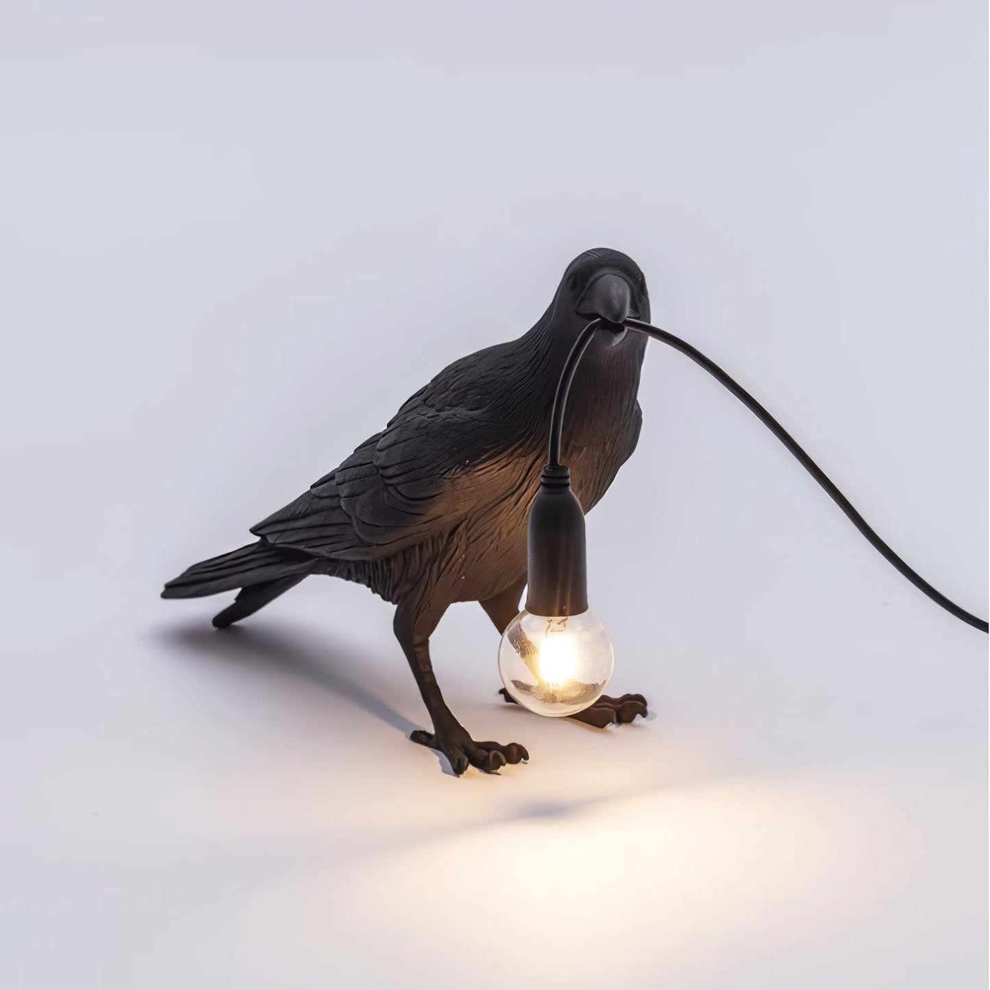 Stolní lampa s havranem držícím žárovku