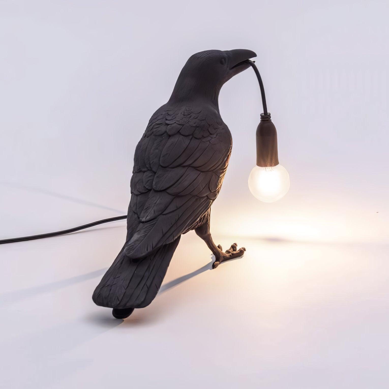 Stolní lampa s havranem držícím žárovku