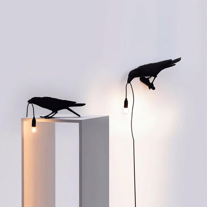 Stolní lampa s havranem držícím žárovku