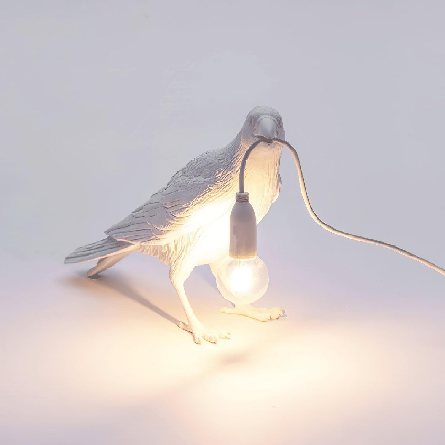 Stolní lampa s havranem držícím žárovku