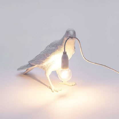 Stolní lampa s havranem držícím žárovku