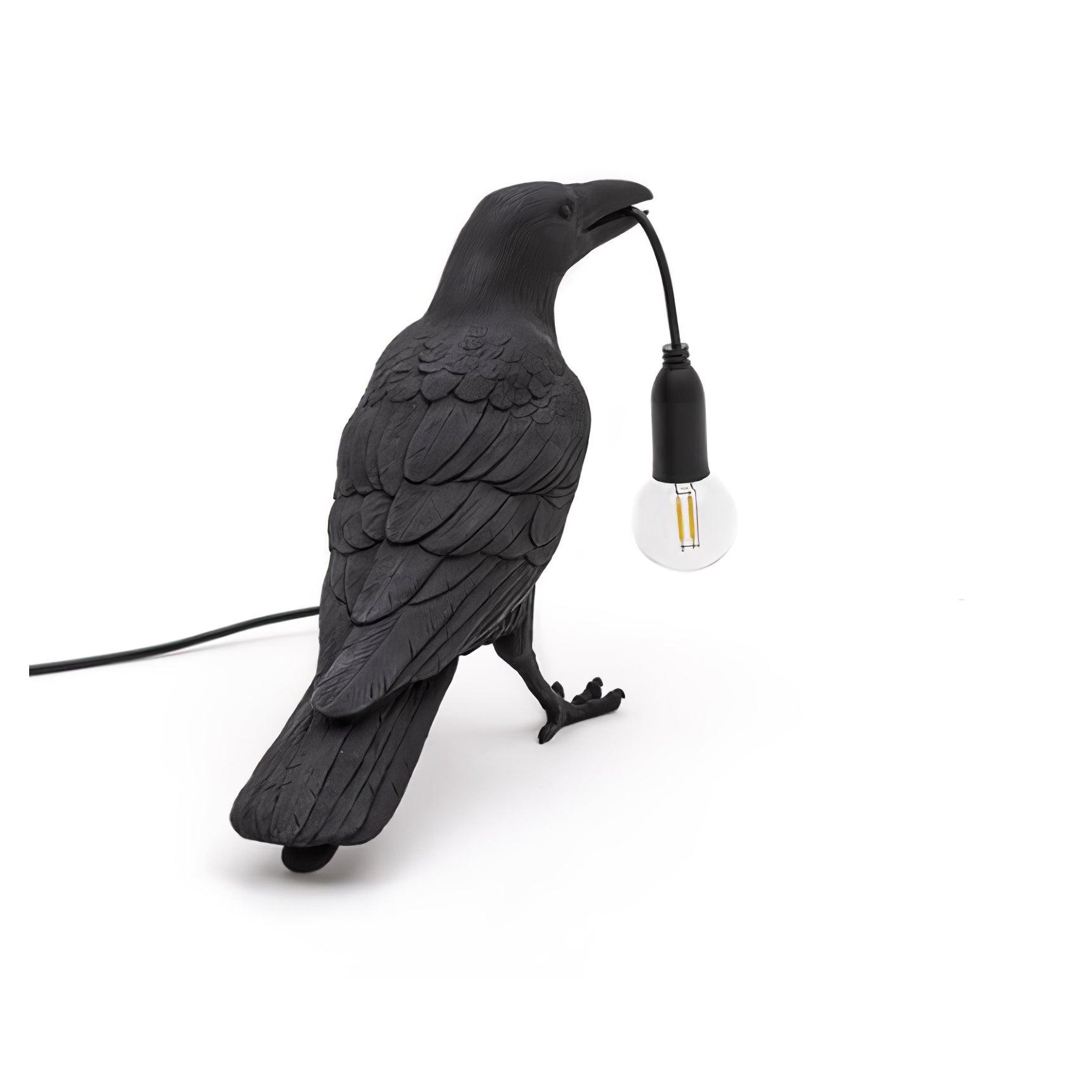 Stolní lampa s havranem držícím žárovku