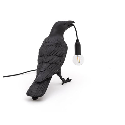 Stolní lampa s havranem držícím žárovku