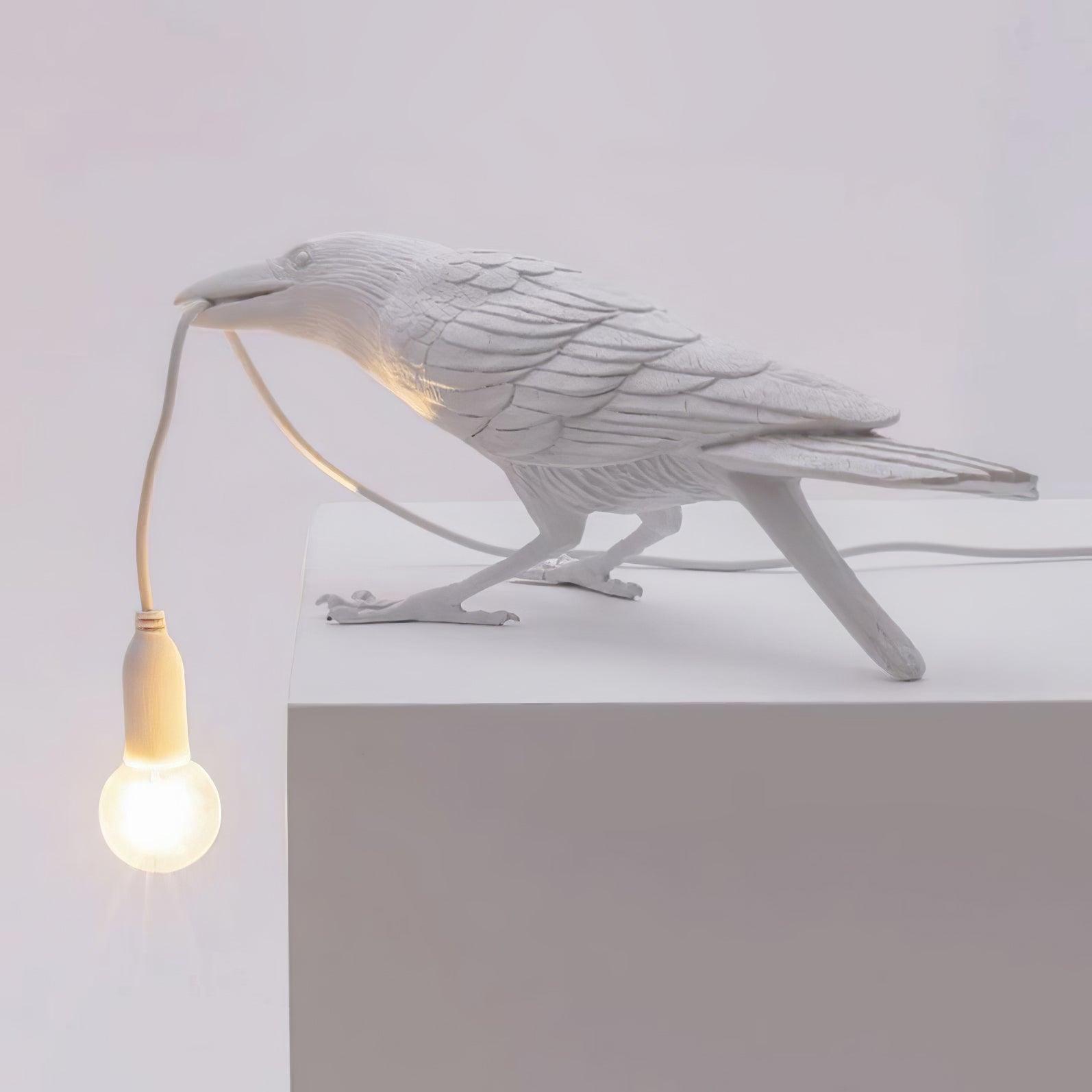 Stolní lampa s havranem držícím žárovku