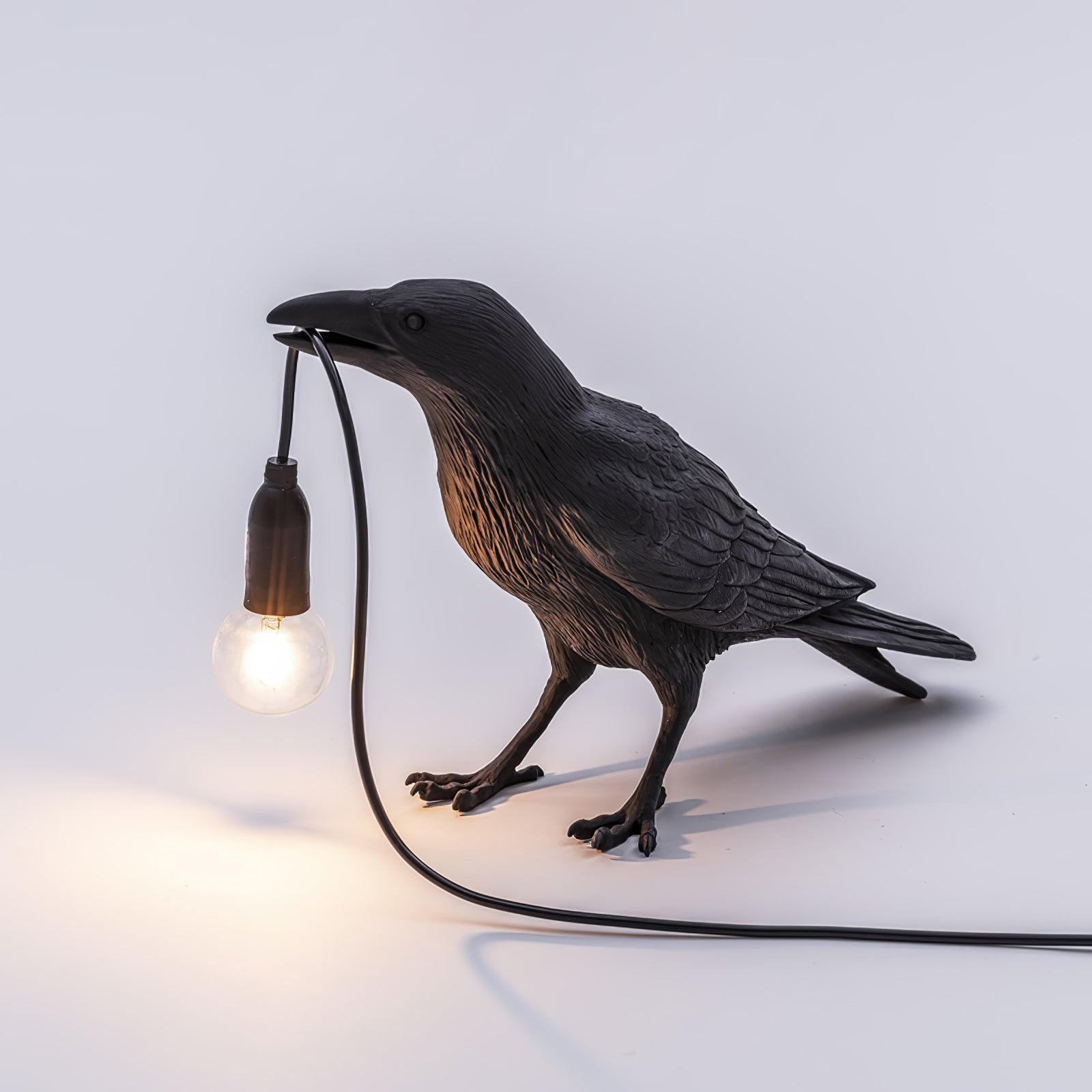 Stolní lampa s havranem držícím žárovku