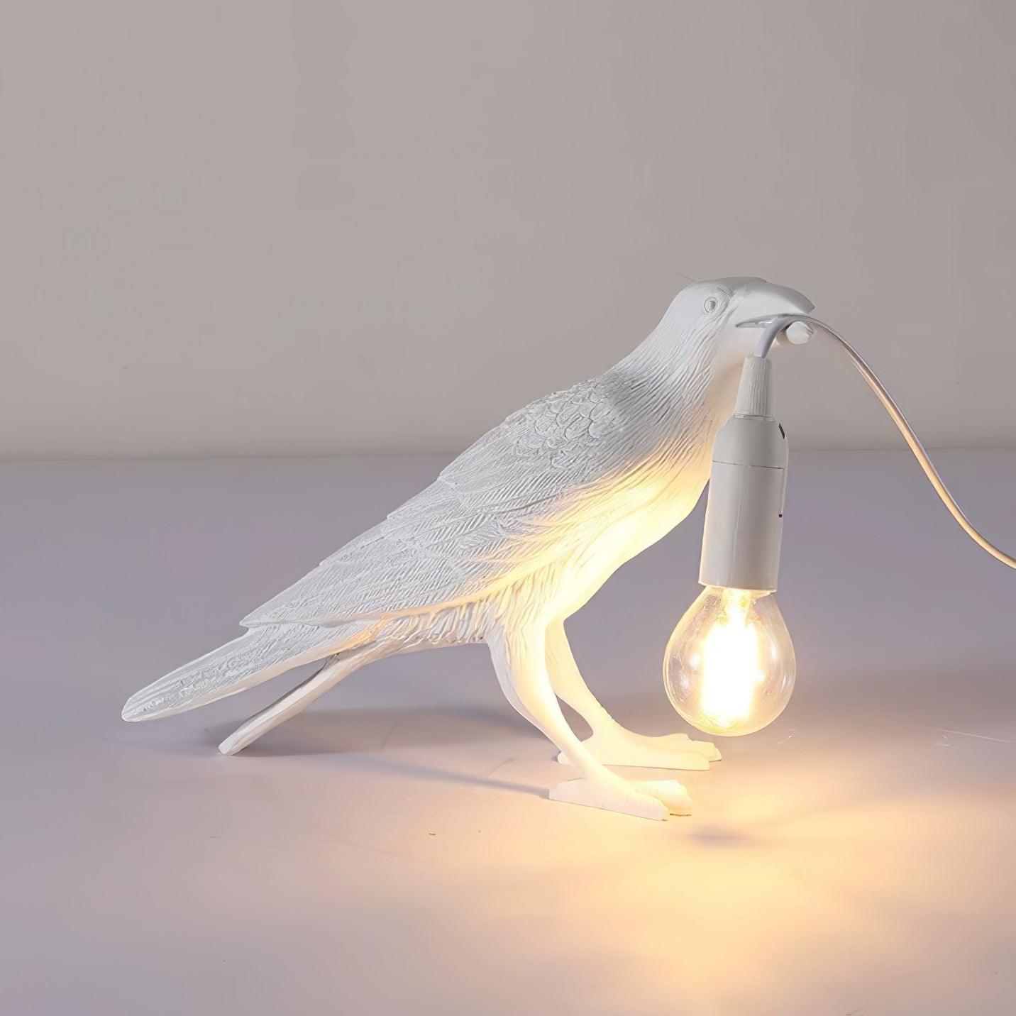 Stolní lampa s havranem držícím žárovku