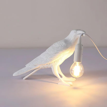 Stolní lampa s havranem držícím žárovku