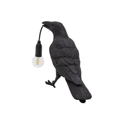 Stolní lampa s havranem držícím žárovku